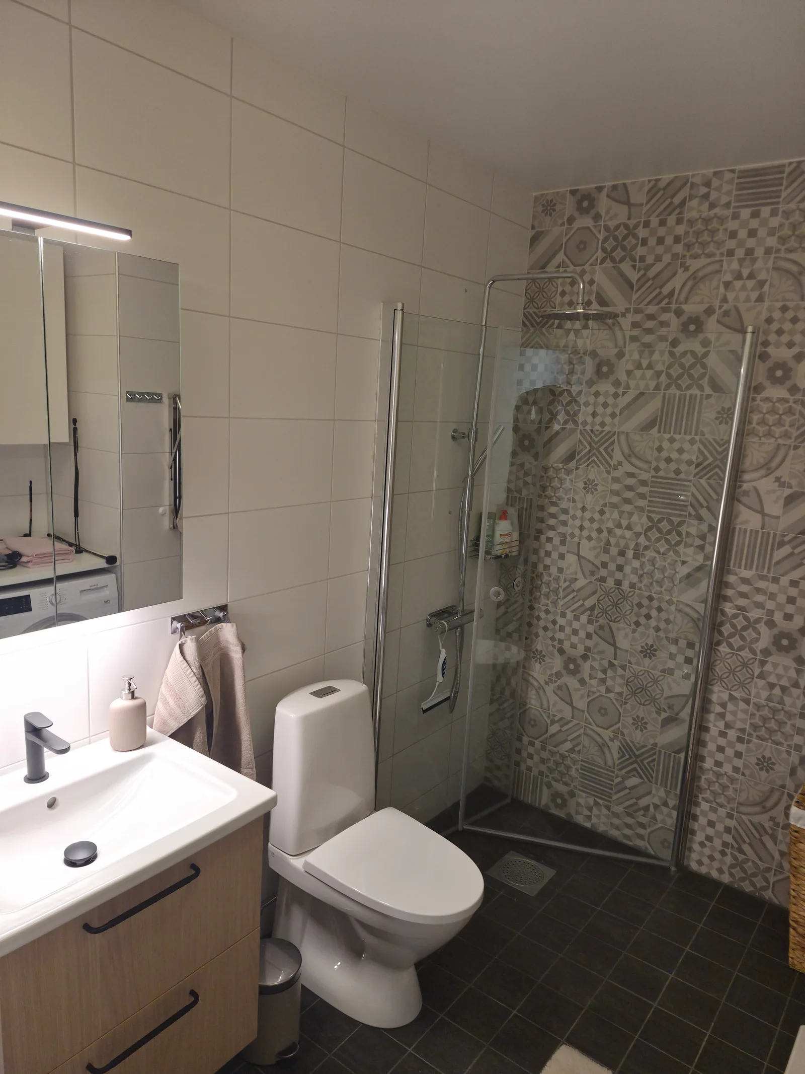 Färdigrenoverat badrum med kommod, wc och dusch med glasvägg